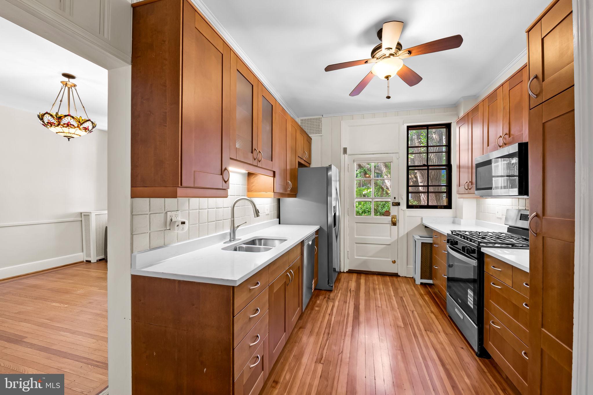 3916 Cloverhill Road Baltimore, MD 21218 - Photo 12 of 47 a kitchen with a stove a sink and a refrigerator