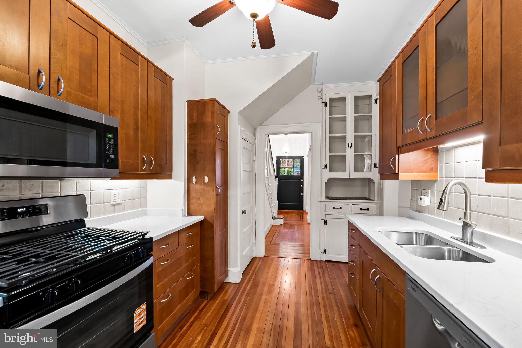 3916 Cloverhill Road Baltimore, MD 21218 - Photo 15 of 47 a kitchen with stainless steel appliances a stove sink microwave and cabinets