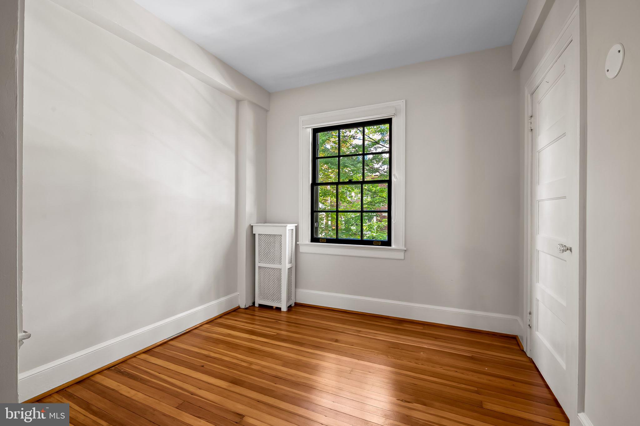 3916 Cloverhill Road Baltimore, MD 21218 - Photo 21 of 47 an empty room with wooden floor and windows