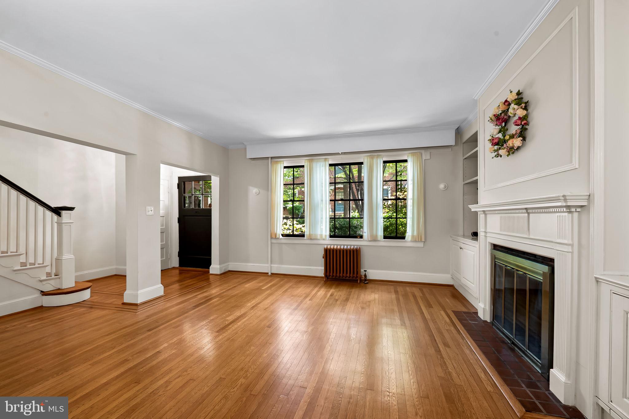 3916 Cloverhill Road Baltimore, MD 21218 - Photo 6 of 47 a view of an empty room with wooden floor fireplace and a window