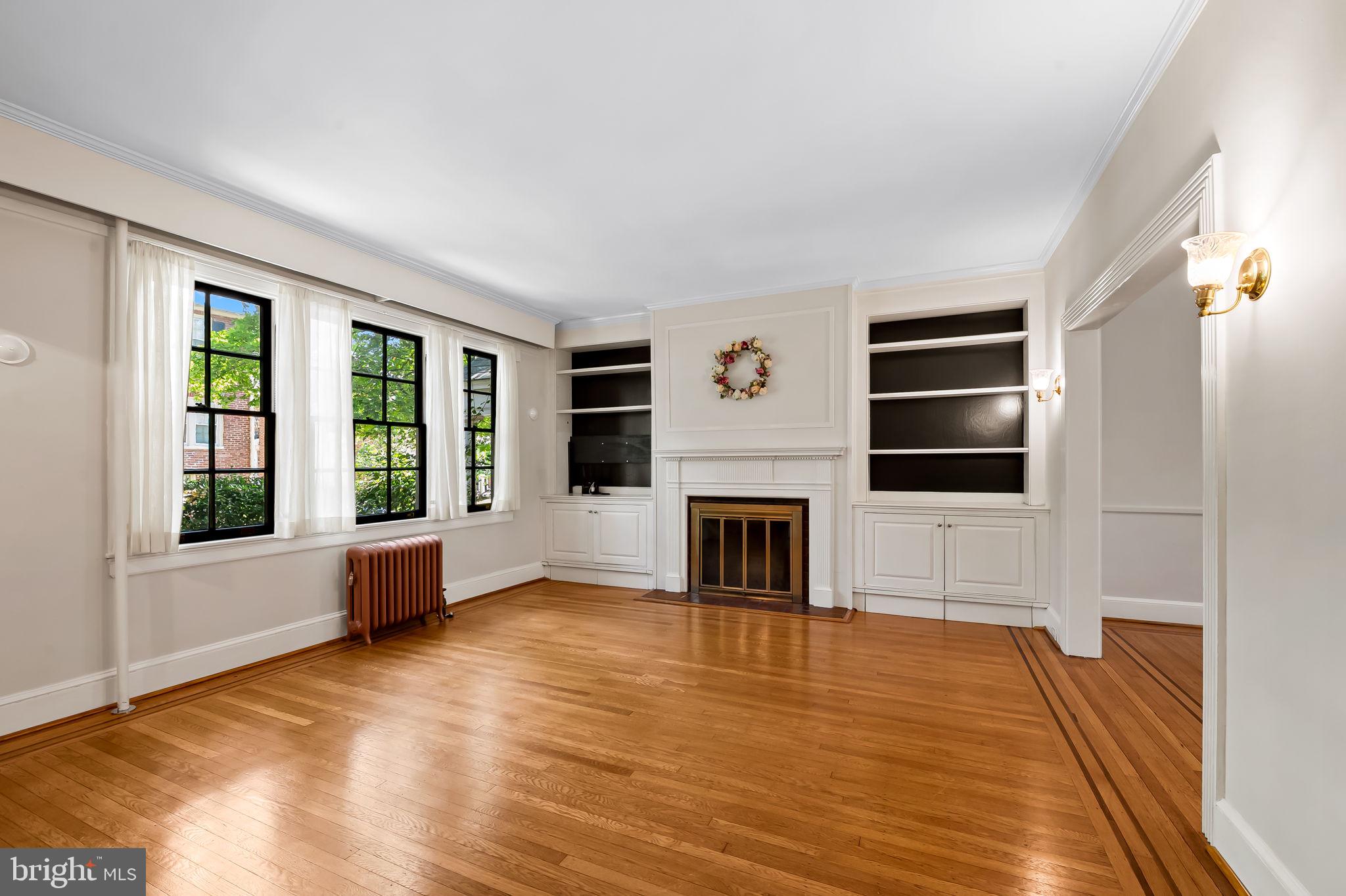 3916 Cloverhill Road Baltimore, MD 21218 - Photo 7 of 47 a view of empty room with wooden floor and fireplace