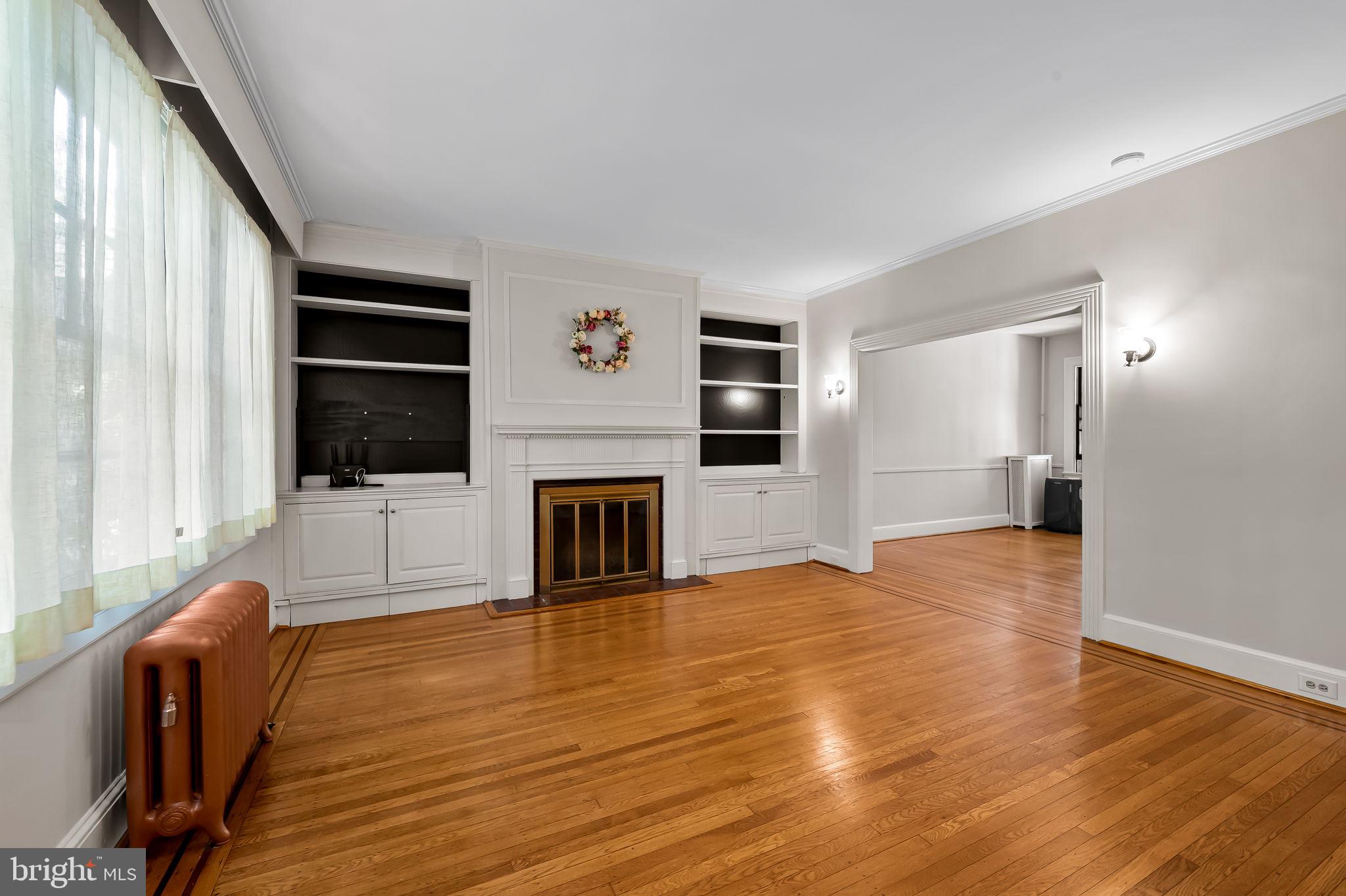 3916 Cloverhill Road Baltimore, MD 21218 - Photo 8 of 47 a view of a livingroom with wooden floor and a fireplace