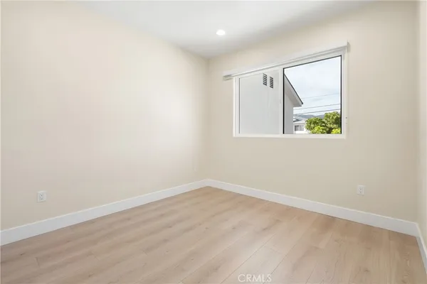 an empty room with wooden floor and a window