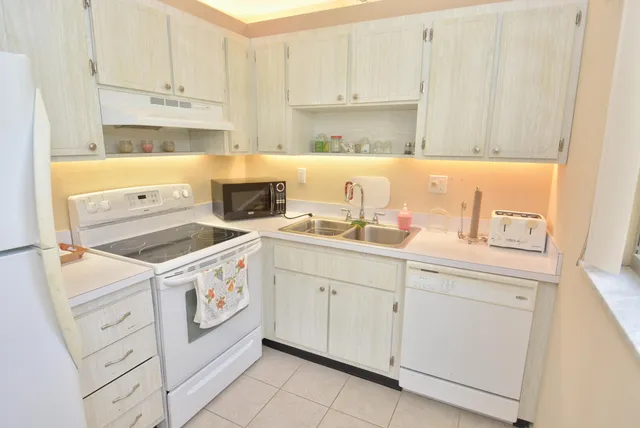 a kitchen with cabinets appliances a sink and a counter top