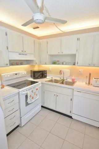a kitchen with cabinets appliances a sink and a window