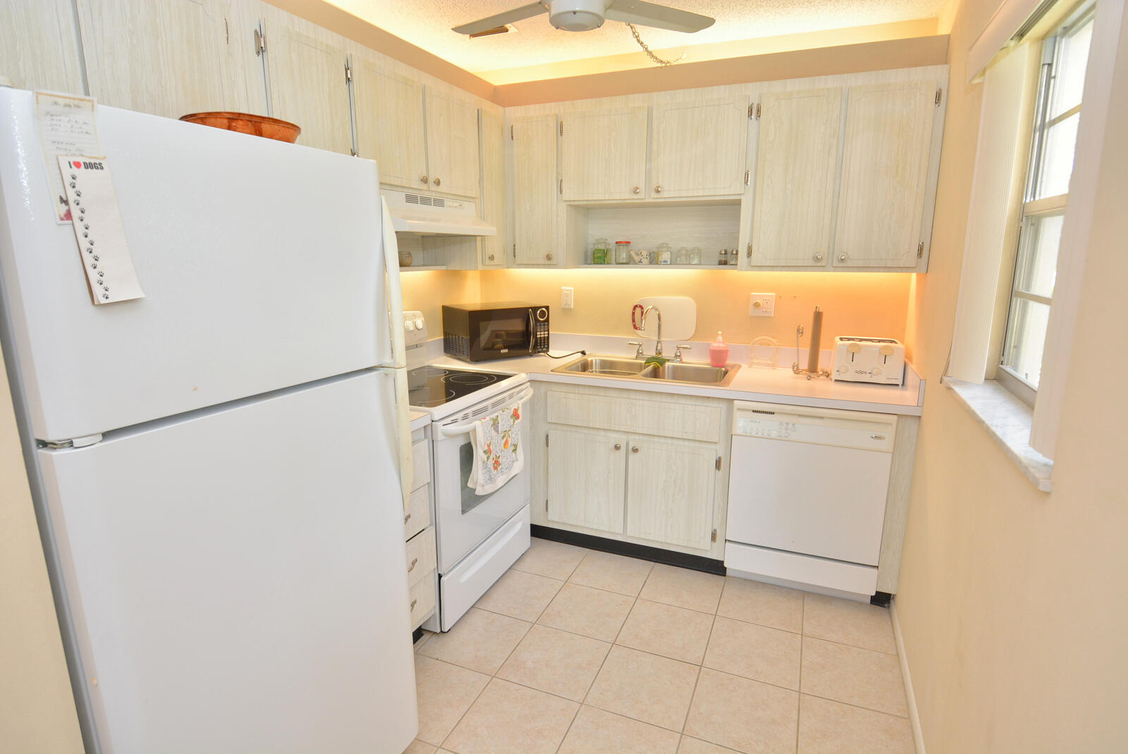 1225 Northwest 21st Street, Unit 2105 Stuart, FL 34994 - Photo 13 of 34 a white refrigerator freezer sitting inside of a kitchen