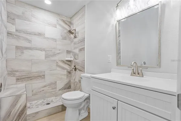 a bathroom with a sink a toilet and shower