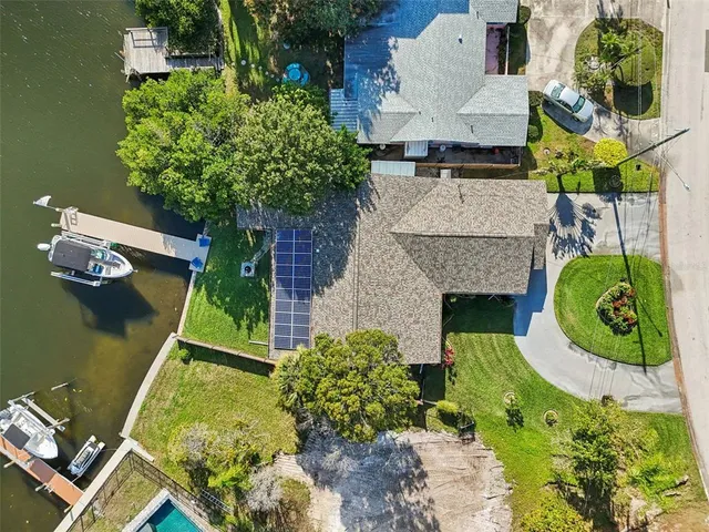 an aerial view of residential houses with outdoor space and trees