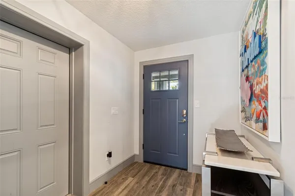 a view of a hallway with wooden floor and a bathroom