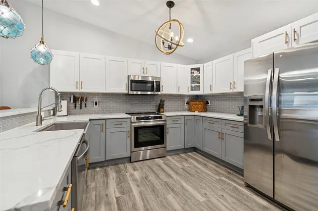 a living room with furniture a flat screen tv and a chandelier