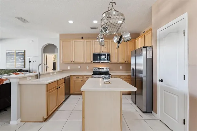 a kitchen with stainless steel appliances granite countertop a sink refrigerator stove and microwave