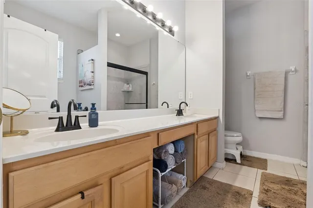 a bathroom with a double vanity sink mirror and toilet