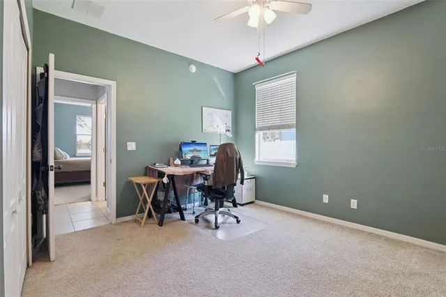 a workspace with chandelier fan and a window