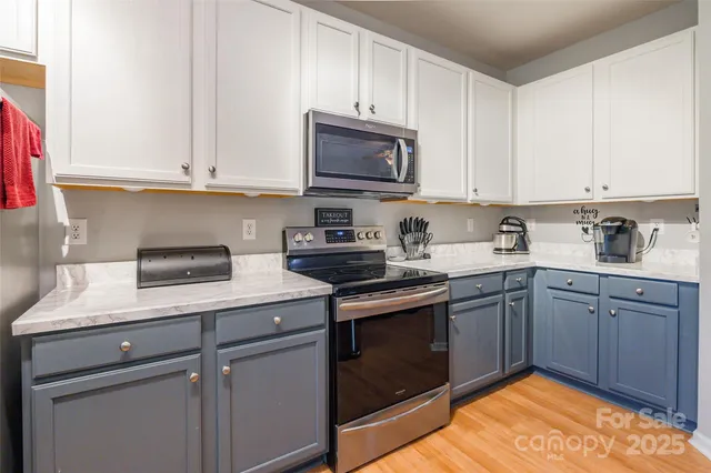 a kitchen with stainless steel appliances granite countertop a sink stove and cabinets