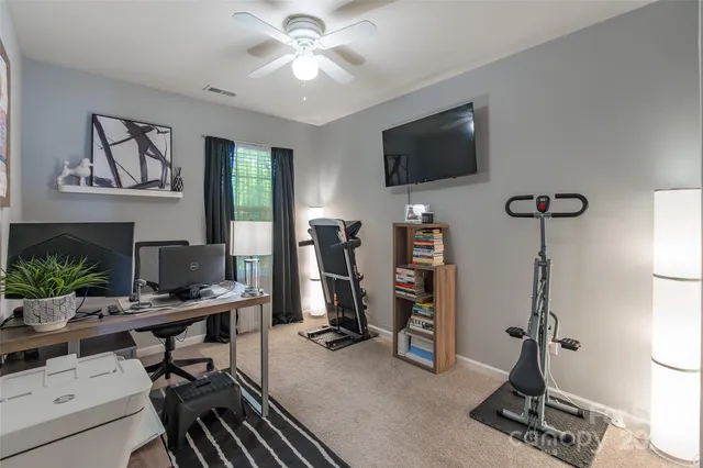 a view of a workspace with furniture and a flat screen tv