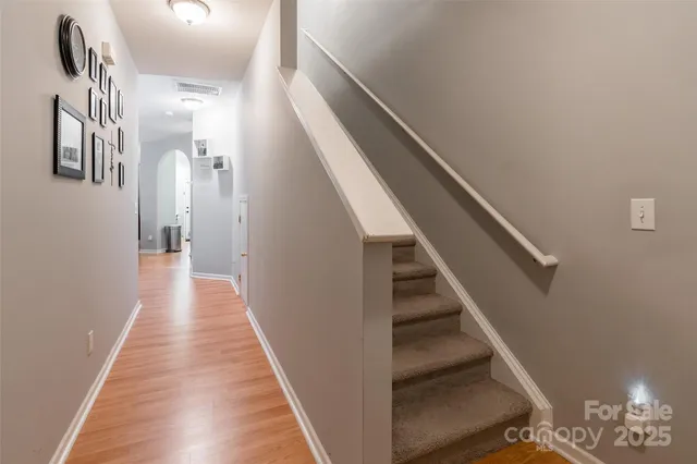a view of a hallway with wooden floor and entryway