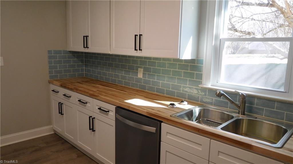 724 Sain Road Mocksville, NC 27028 - Photo 7 of 21 All New Kitchen: White shaker style cabinets with black pulls, tile backsplash & butcher block counters.