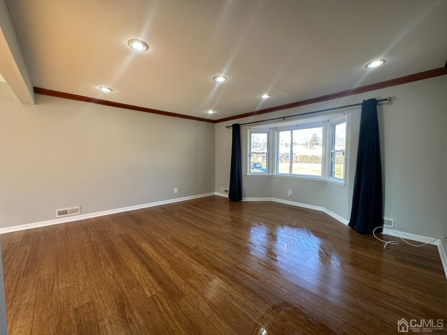 3 Hill Road Edison, NJ 08817 - Photo 3 of 27 a view of an empty room with wooden floor and a window