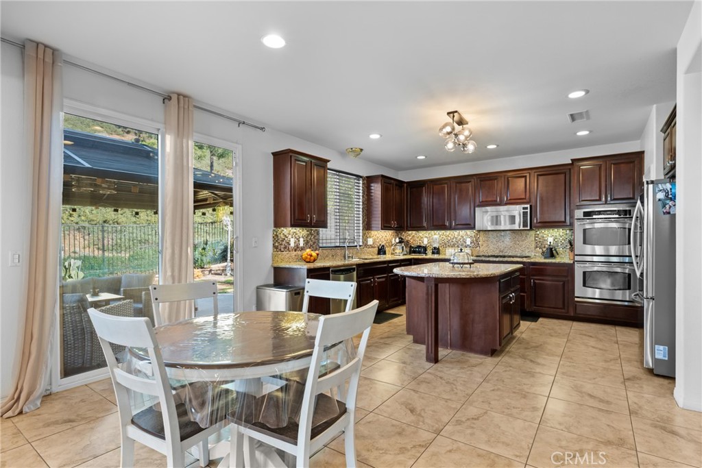 35424 Saddle Hill Road Lake Elsinore, CA 92532 - Photo 19 of 63 a kitchen with a dining table chairs and refrigerator