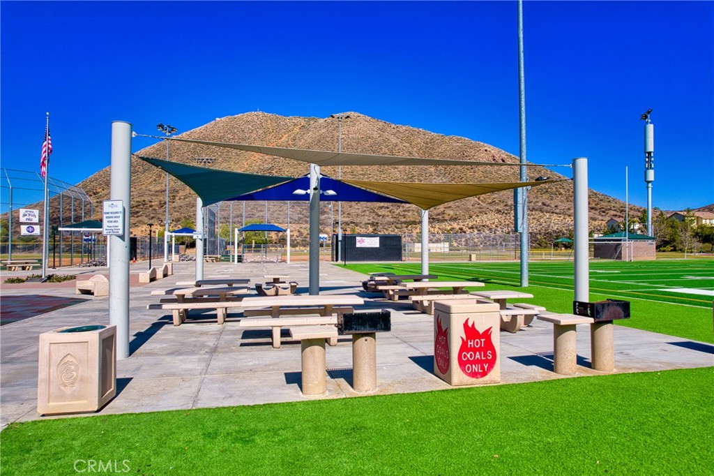 35424 Saddle Hill Road Lake Elsinore, CA 92532 - Photo 58 of 63 a view of a patio with chairs and table under an umbrella