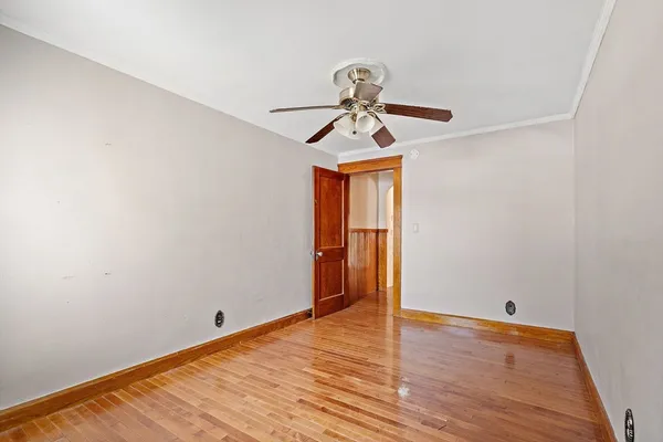 a view of room with wooden floor and ceiling fan