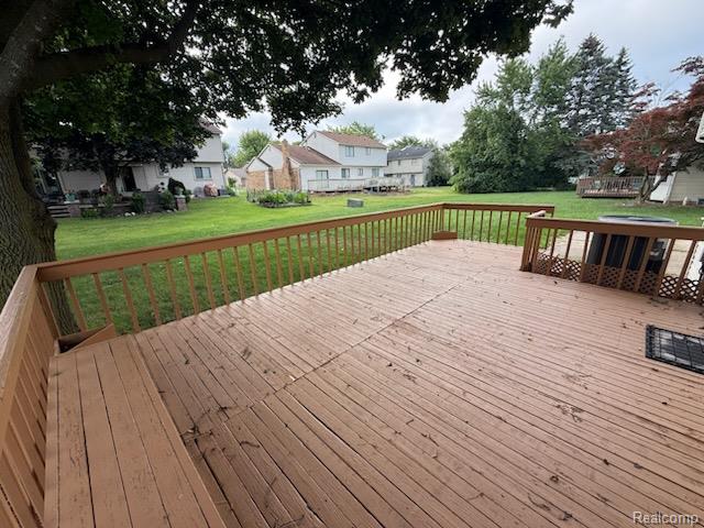 28144 Yorktown Road Farmington, MI 48331 - Photo 22 of 25 Expansive wood deck with a built-in bench, offering a broad view of the large grassy yard and mature trees