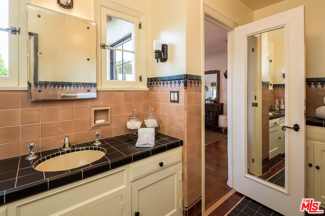 4342 Cedarhurst Circle Los Angeles, CA 90027 - Photo 28 of 44 a bathroom with a granite countertop sink a mirror and a shower
