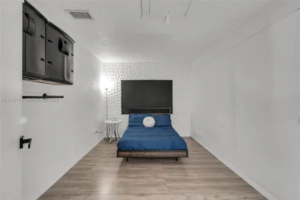 a living room with wooden floor and flat screen tv