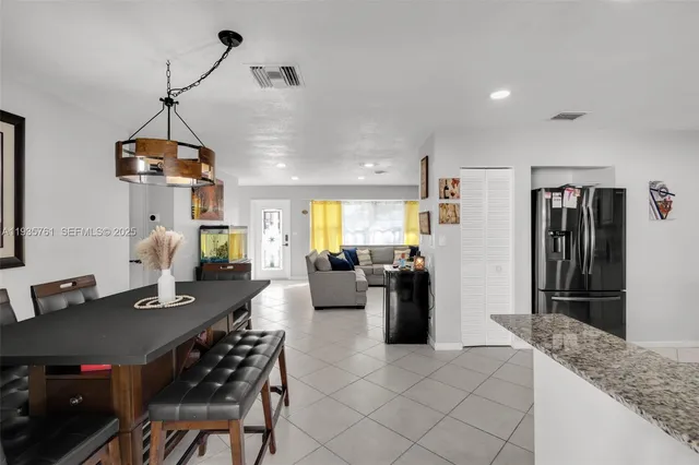 a dining room with kitchen island furniture and a chandelier