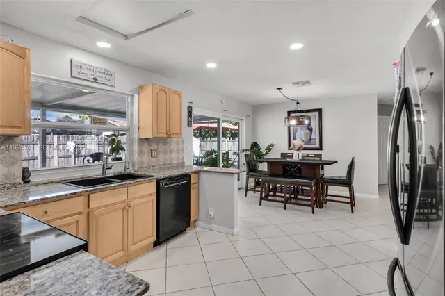 a kitchen with granite countertop a sink stainless steel appliances and cabinets