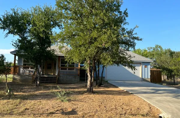 a view of a house with street that has a tree
