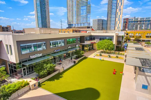 a front view of multi story residential apartment building with retail shops