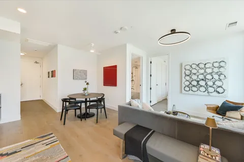 a living room with furniture appliances and a large window