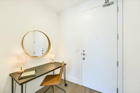 a kitchen with stainless steel appliances granite countertop a stove top oven a sink dishwasher and white cabinets with wooden floor