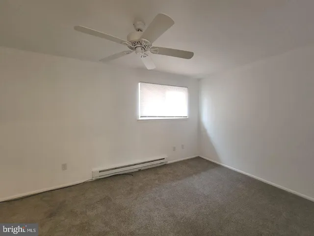 an empty room with a window and a fan