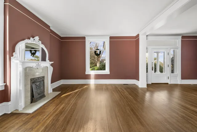 a view of empty room with wooden floor and fireplace