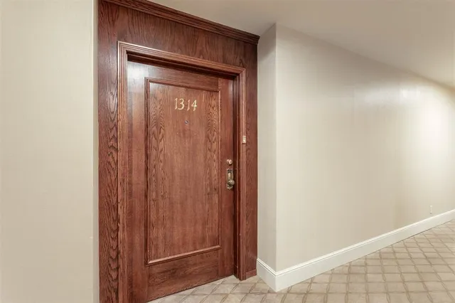 a view of a hallway with a dining room and front door