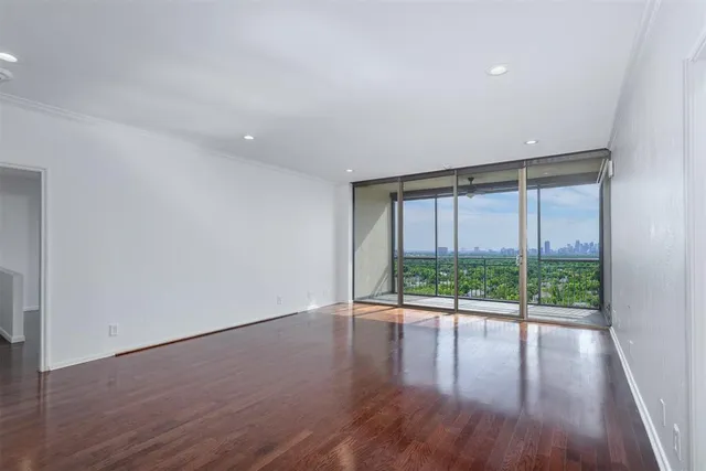 a view of empty room with wooden floor and floor to ceiling window
