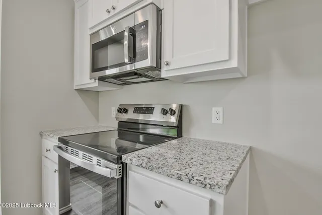 a kitchen with stainless steel appliances granite countertop a stove microwave and sink