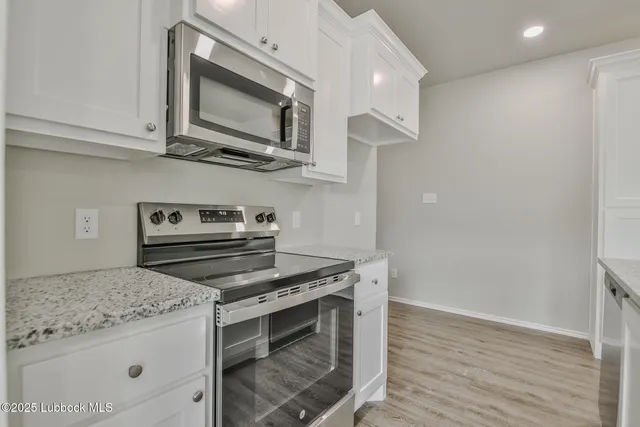 a kitchen with stainless steel appliances granite countertop a stove and a microwave