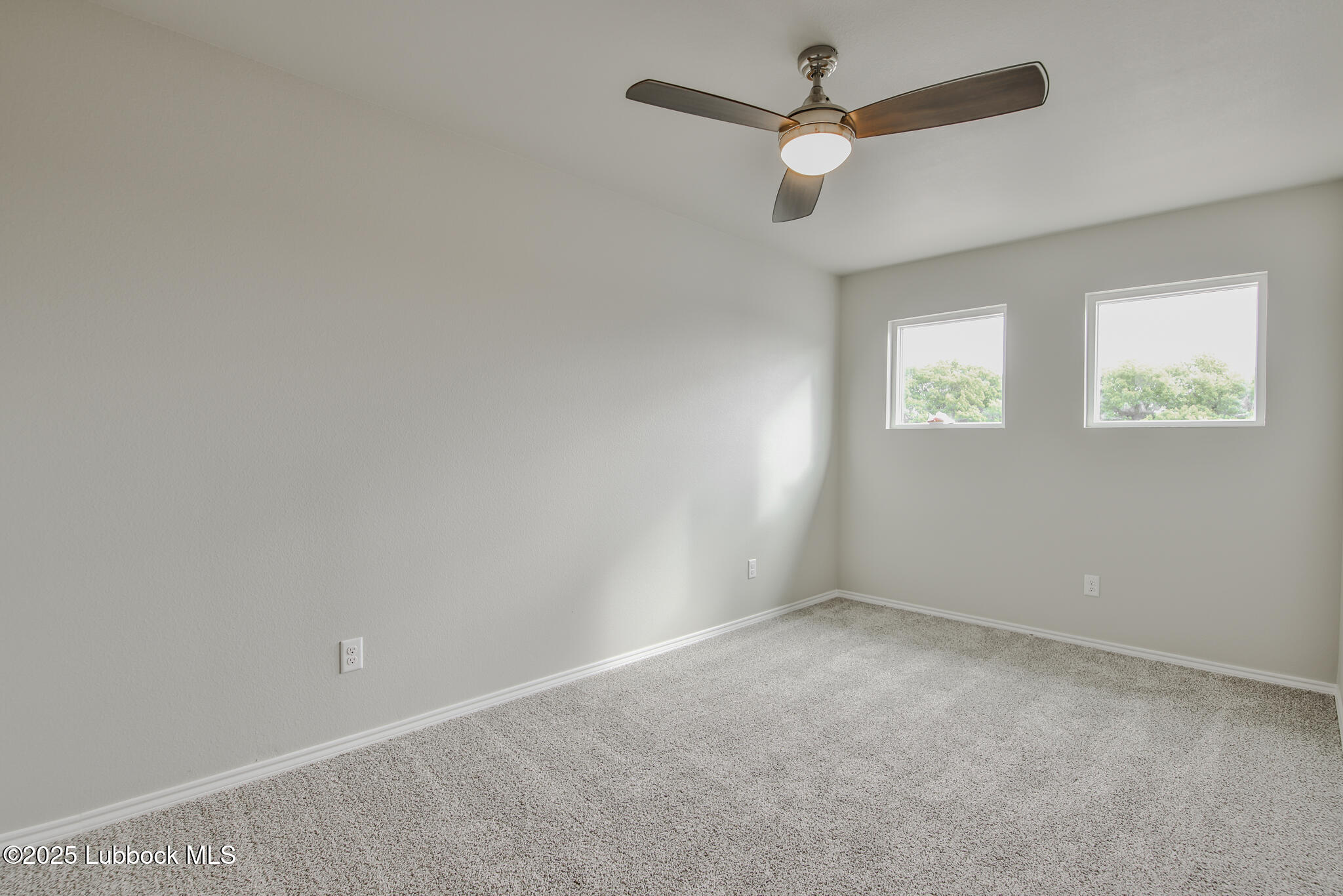 3117 74th Street Lubbock, TX 79423 - Photo 23 of 36 an empty room with a window and a fan