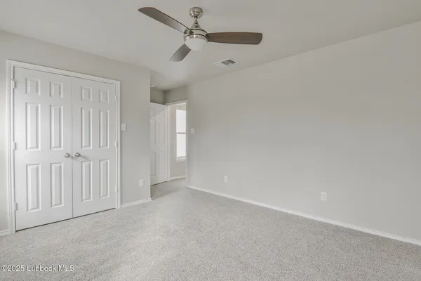 an empty room with a ceiling fan