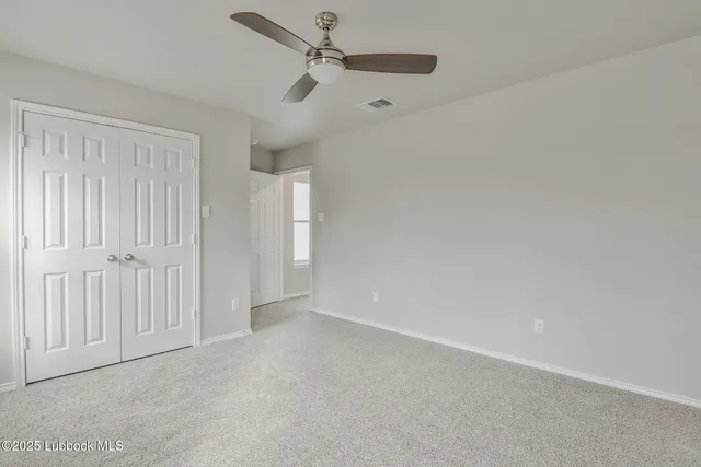 an empty room with a ceiling fan