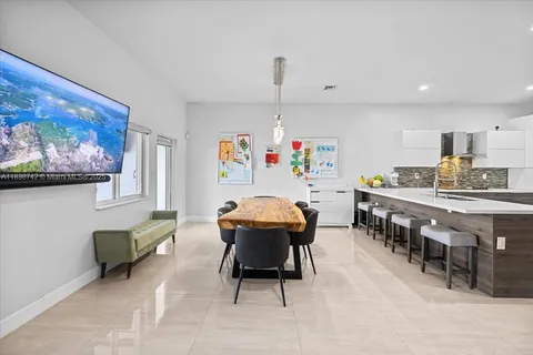a dining room with kitchen island stainless steel appliances furniture a dining table and chairs