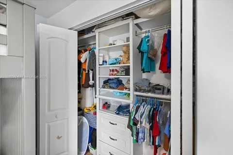 a view of walk in closet with clothes and shoes