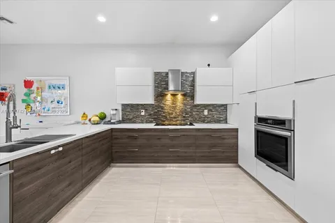 a large white kitchen with a stove a sink and a refrigerator