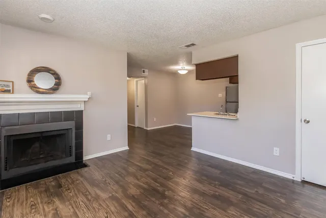 a view of empty room with wooden floor and fireplace