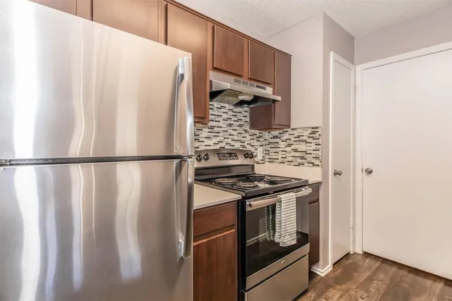 a kitchen with wooden cabinets and a stove top oven