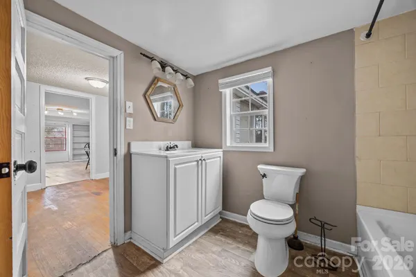a bathroom with a granite countertop sink mirror toilet and bathtub