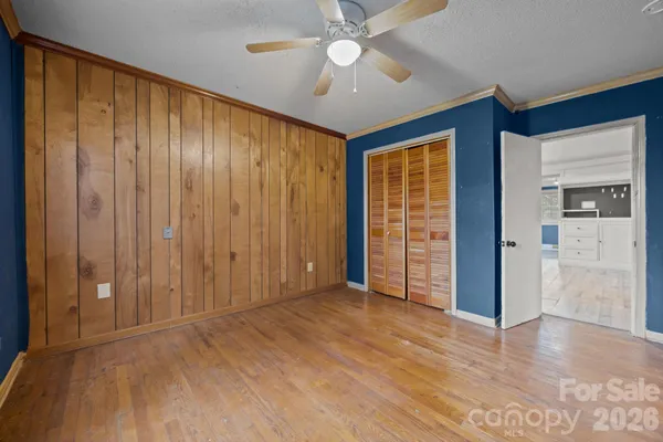 an empty room with windows and ceiling fan